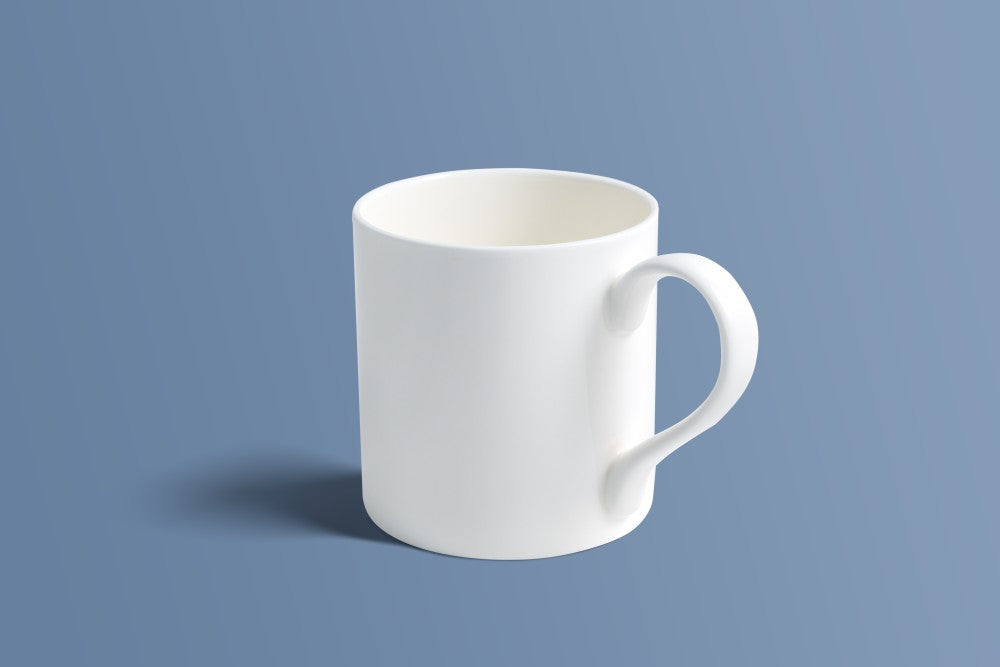 Plain white bone china mug with a shaped handle, shown on a plain background.