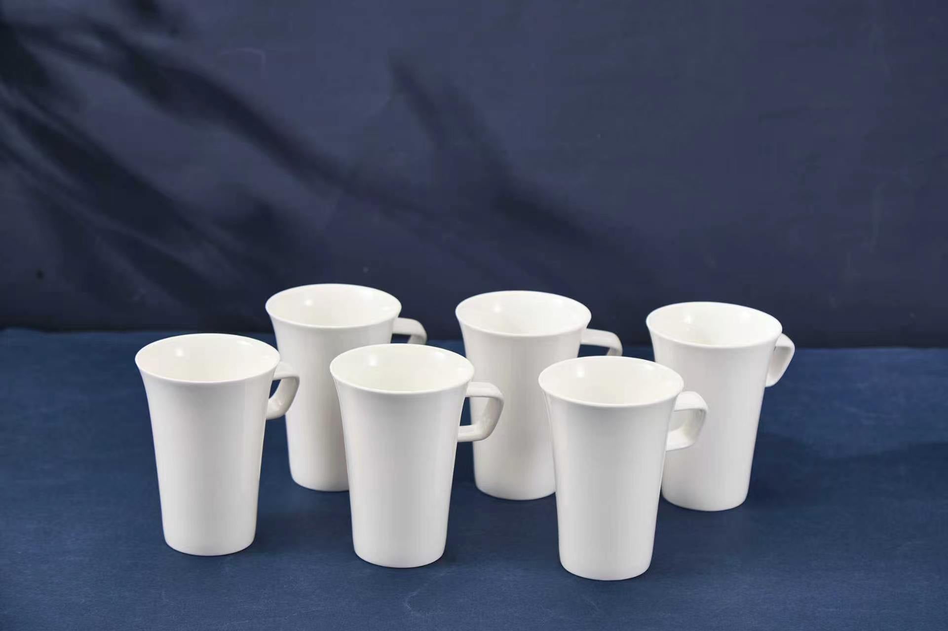 Set of white ceramic mugs on a blue background
