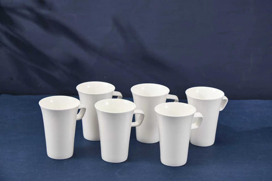 Set of white ceramic mugs on a blue background