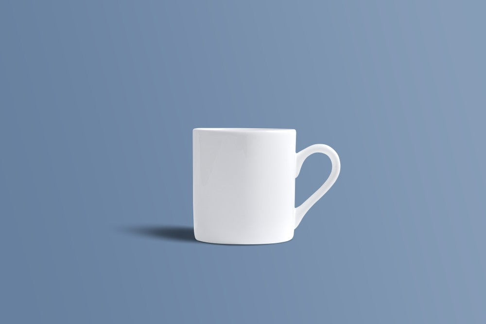 A plain white ceramic coffee mug with a handle, shown from a side profile against a solid slate blue background.