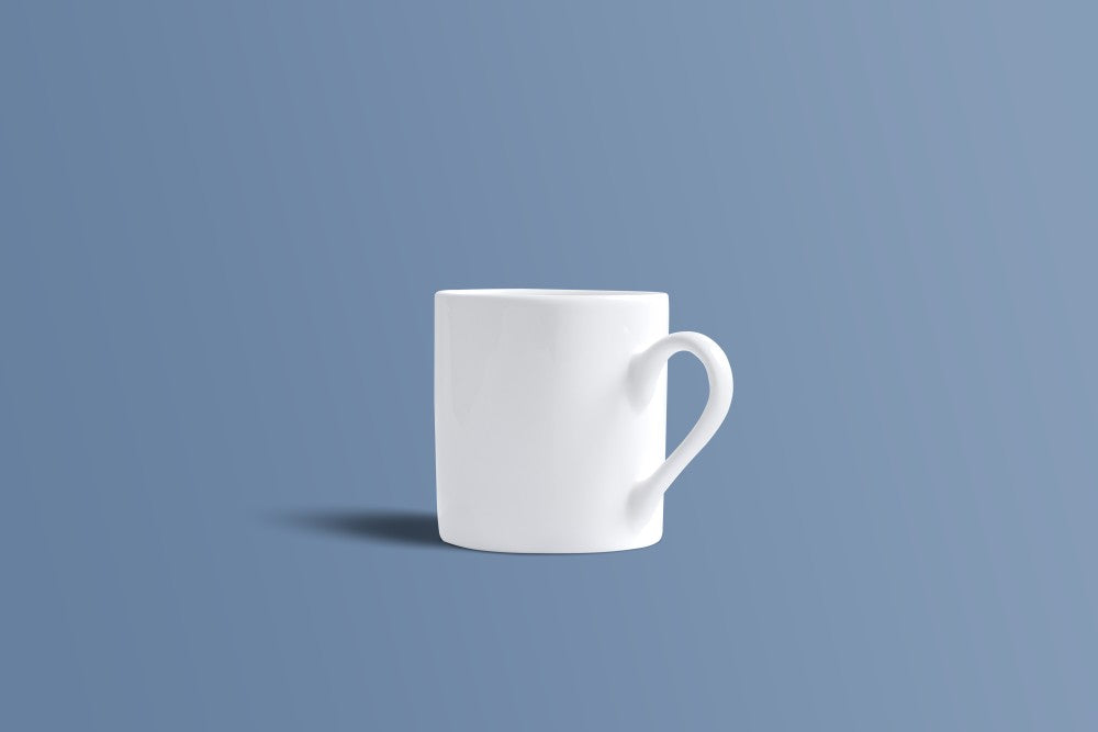 A plain white ceramic mug with a handle, shown from a side angle against a solid blue-gray background.