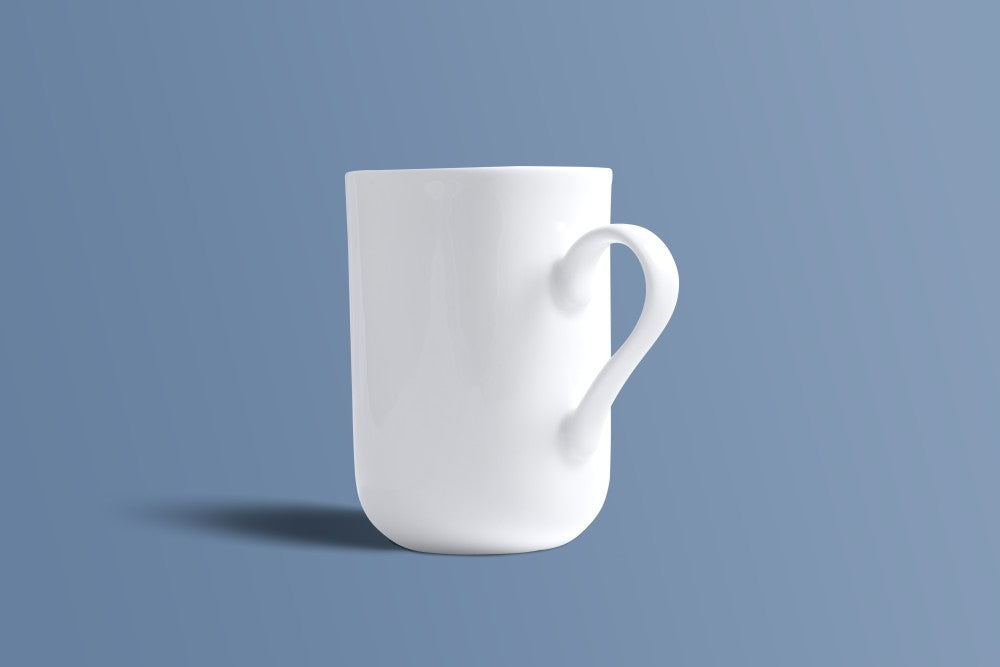 Plain white bone china mug showing the shaped handle and slim tapered body.