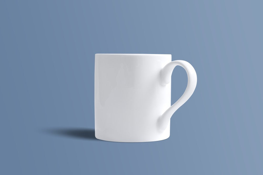 Plain white bone china mug at a three-quarter angle, showing the shaped handle.