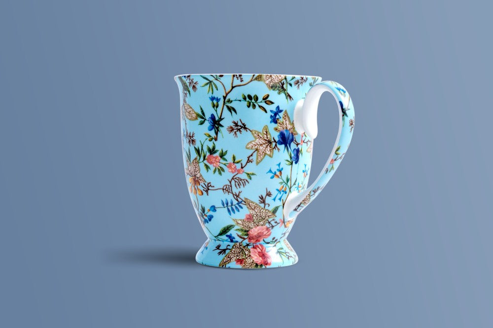 Tall footed Botanica Blue bone china coffee mug shown from the side.