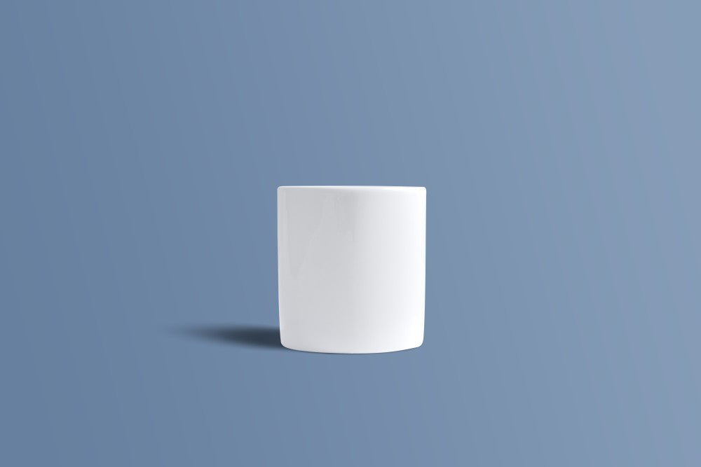 A plain white cylindrical cup or mug centered on a muted blue background with a soft shadow underneath.