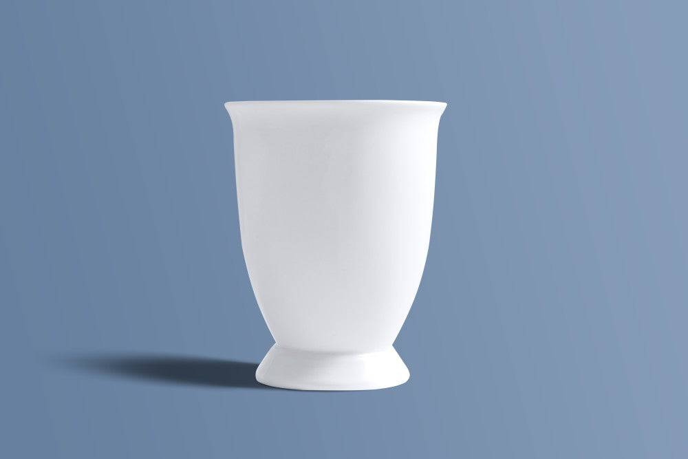 Plain white bone china footed mug seen from the back, showing its tall profile.