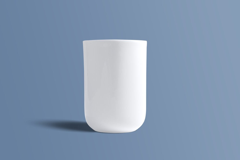 Plain white bone china mug showing its small rounded foot and tall profile.
