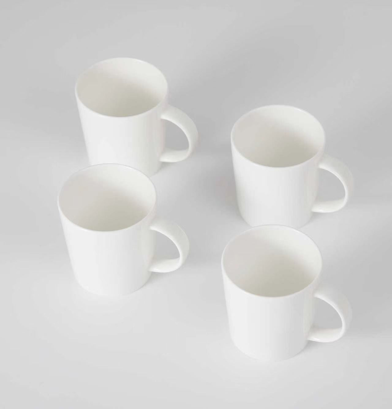 Four white mugs on a light gray background