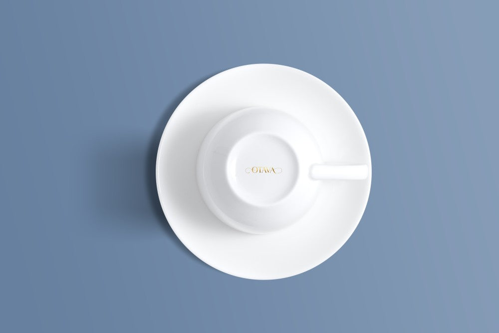 Plain white bone china cup and saucer viewed from above, with the Otava mark inside the rim.