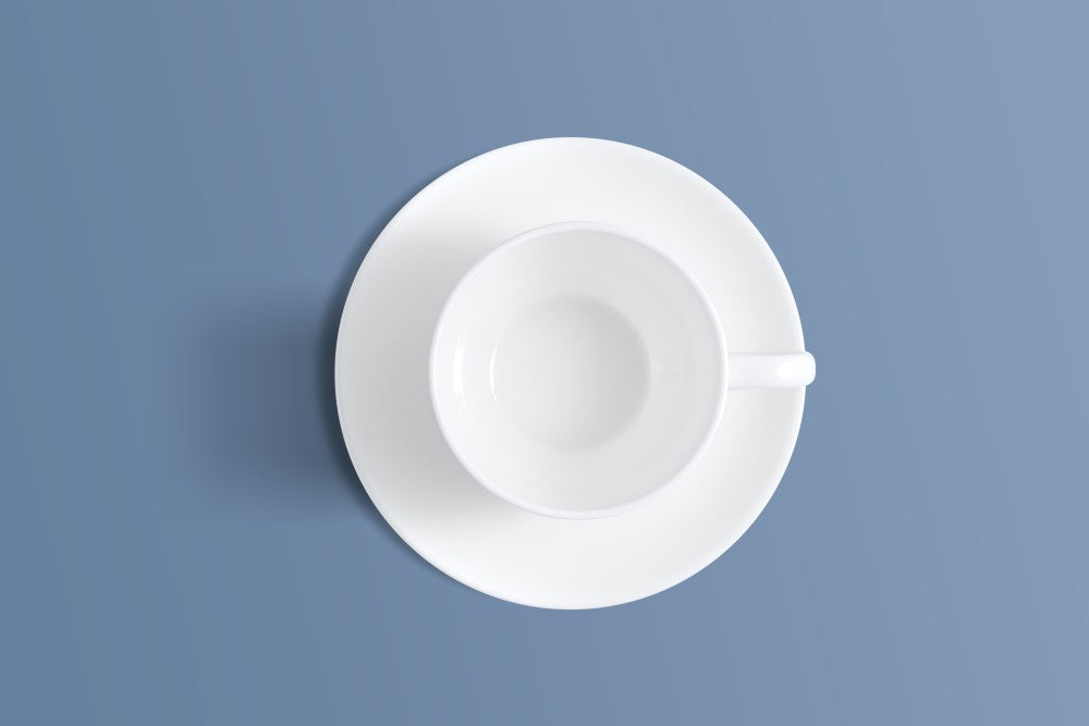 Plain white bone china coffee cup and saucer photographed from directly above.