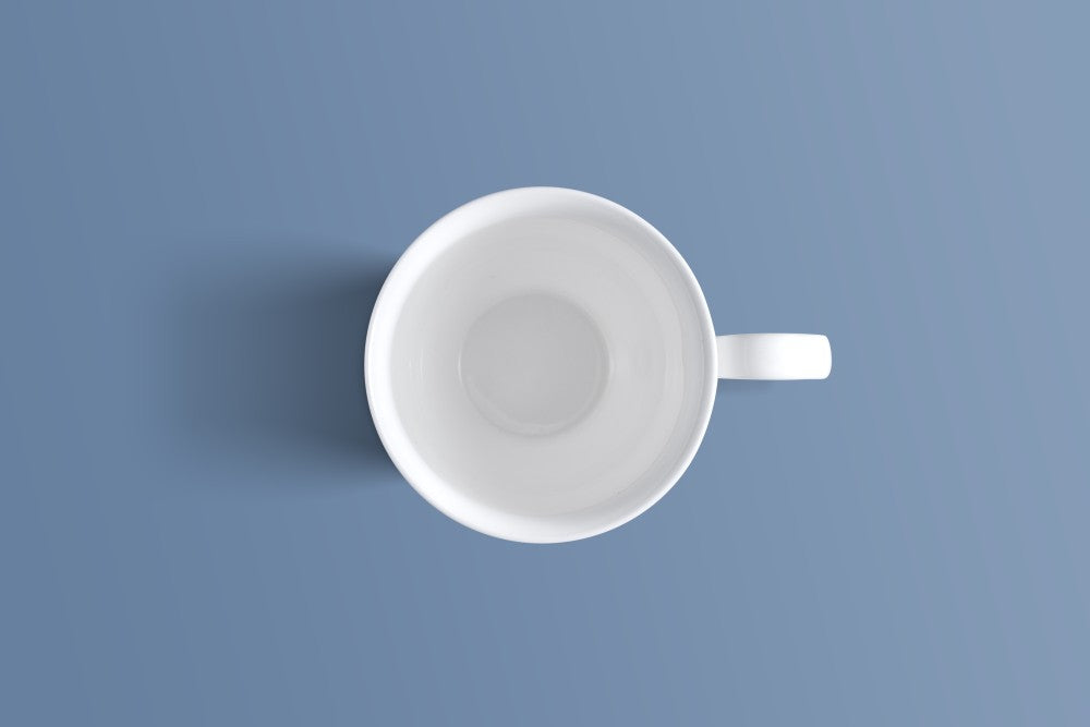 Overhead view of the plain white bone china footed mug and its handle.
