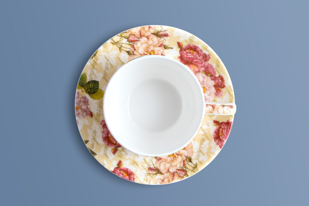 Rose & Verse bone china cup resting on its floral saucer, viewed from directly above.