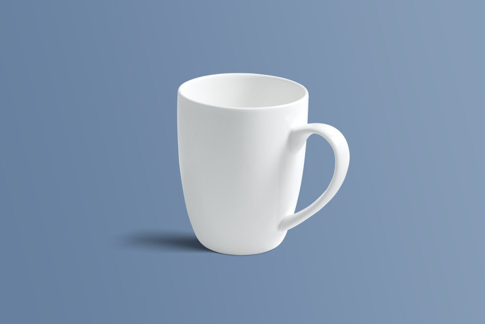 Plain white bone china mug at a three-quarter angle, showing the shaped handle.