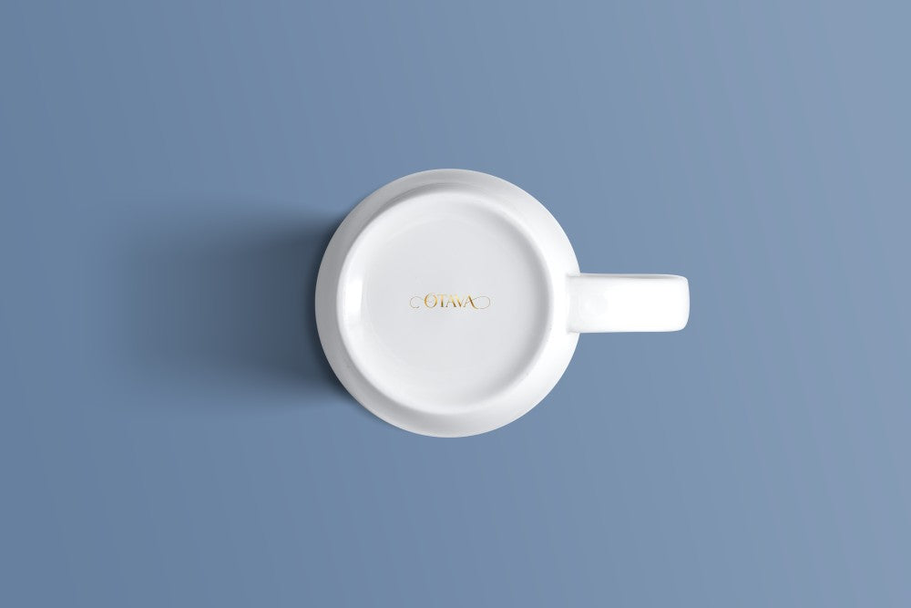 Plain white bone china mug viewed from above, with the Otava mark inside the base.